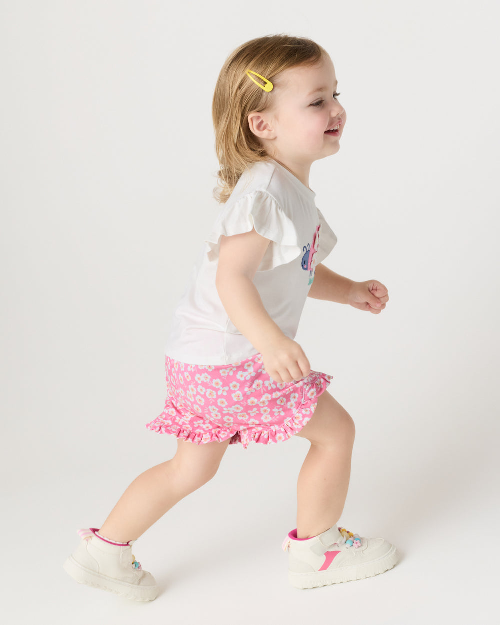 Running child wearing the Sweet Pink Petals Ruffle Shorts