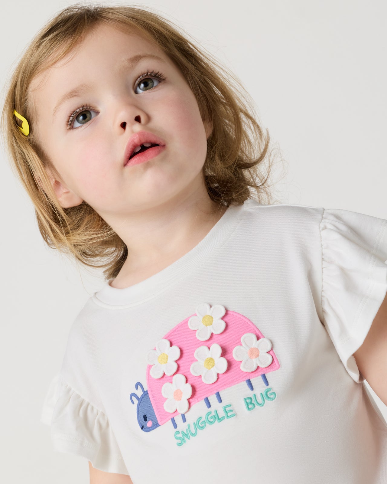 Close up of toddler wearing the Snuggle Bug Flutter Tee