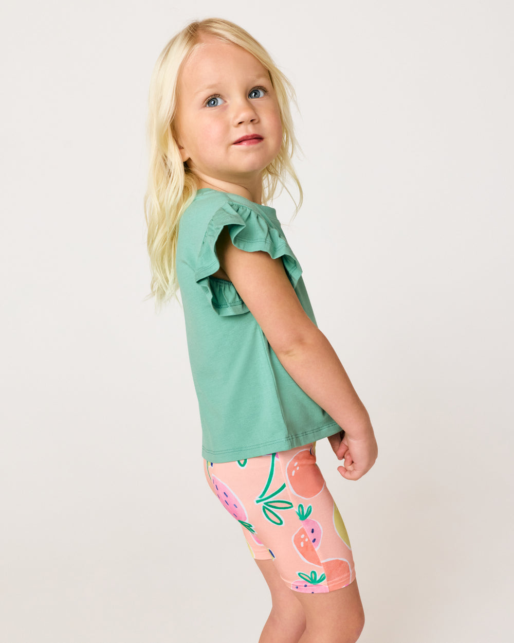 Girl wearing the Cool Jade Flutter Tee with the fruit frenzy bike shorts