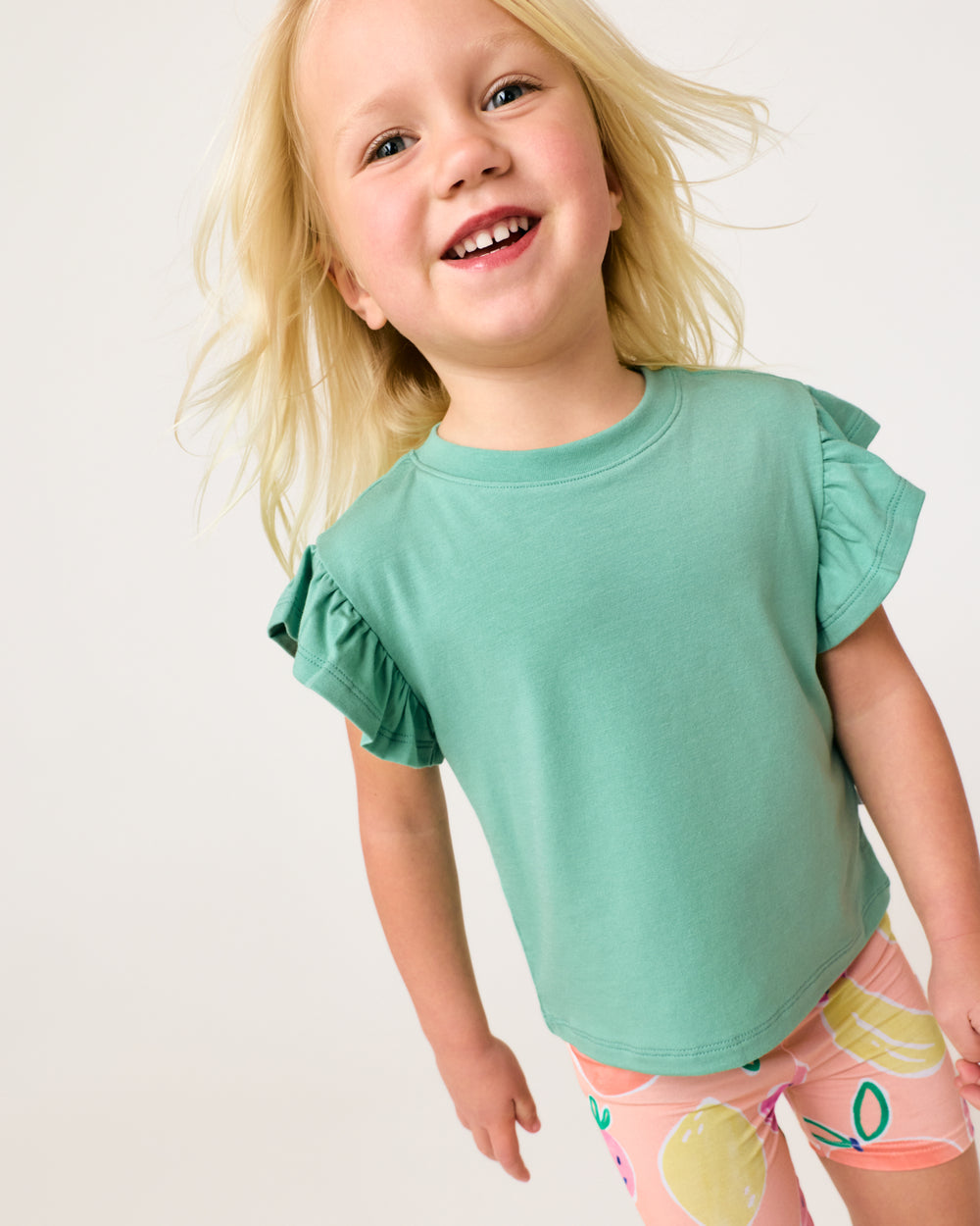 Close up of girl wearing the Cool Jade Flutter Tee