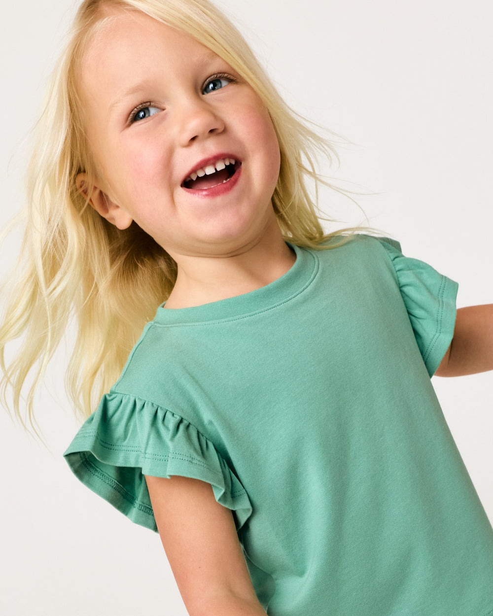Close up of girl wearing the Cool Jade Flutter Tee