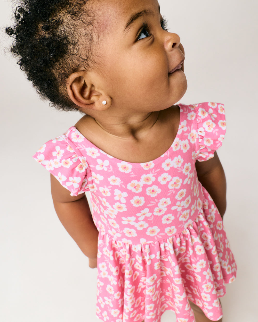 Close up of girl wearing the Sweet Pink Petals Flutter Twirl Dress with Bodysuit