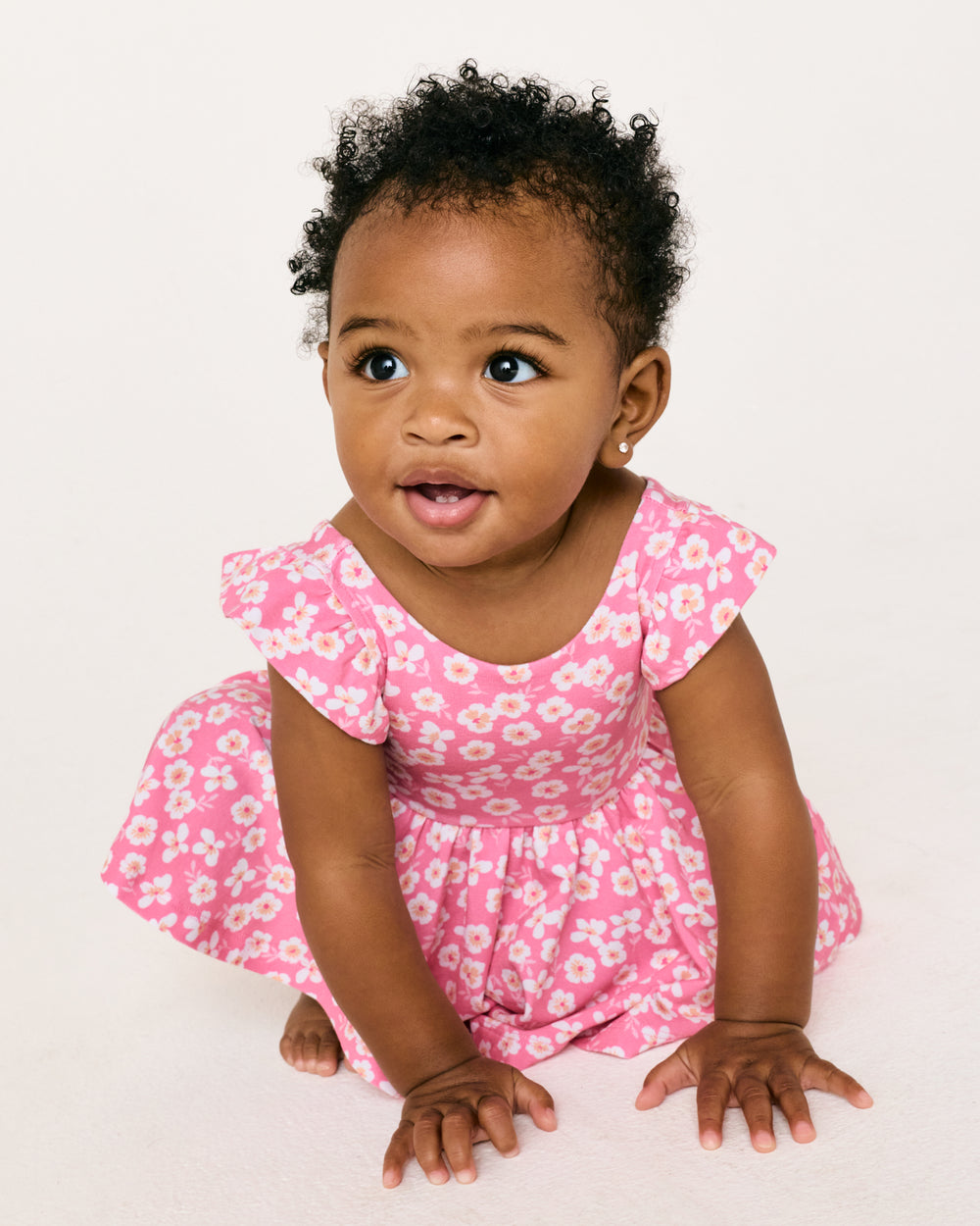 Sitting baby wearing the Sweet Pink Petals Flutter Twirl Dress with Bodysuit