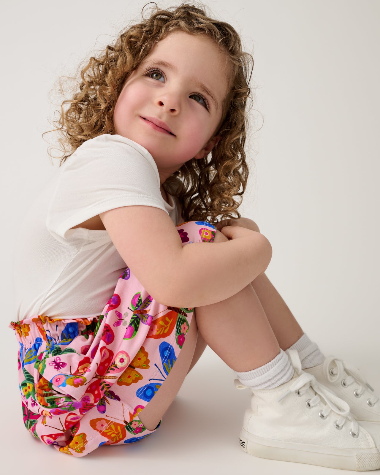 Sitting girl wearing the Flutter Garden Skort