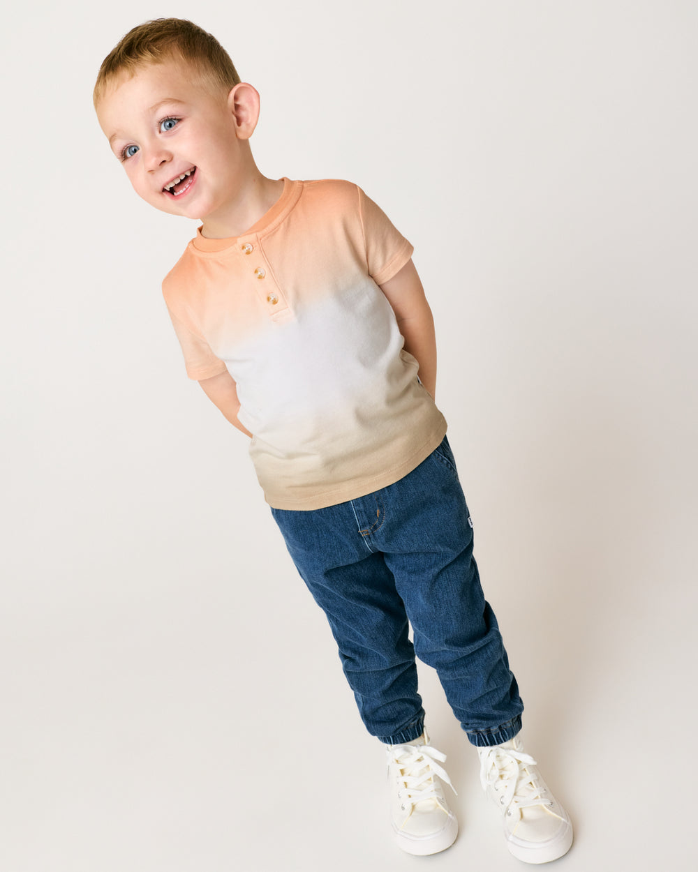 Boy wearing the Golden Hour Henley Tee with denim joggers