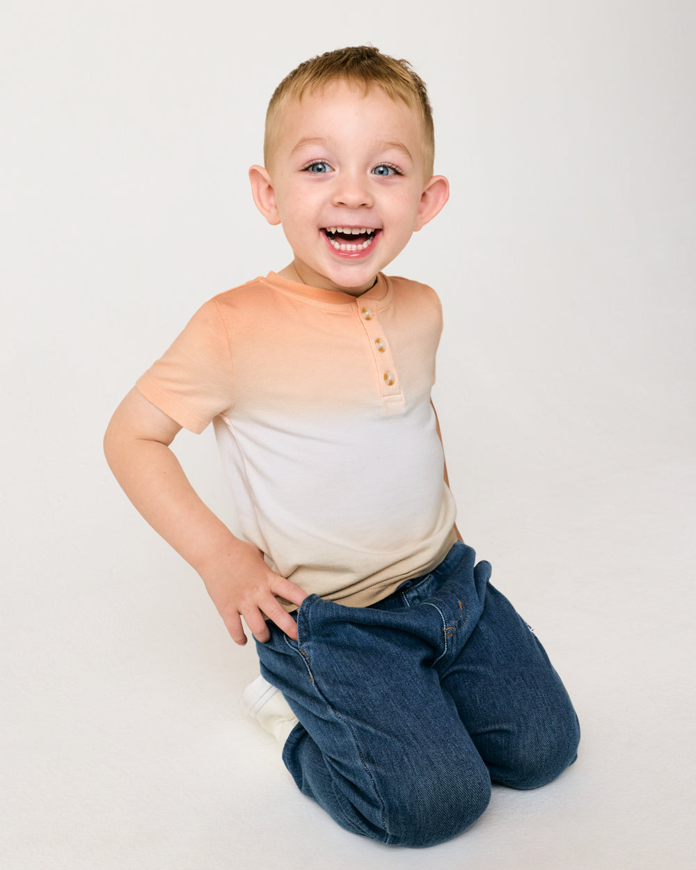 Sitting child wearing the Golden Hour Henley Tee 