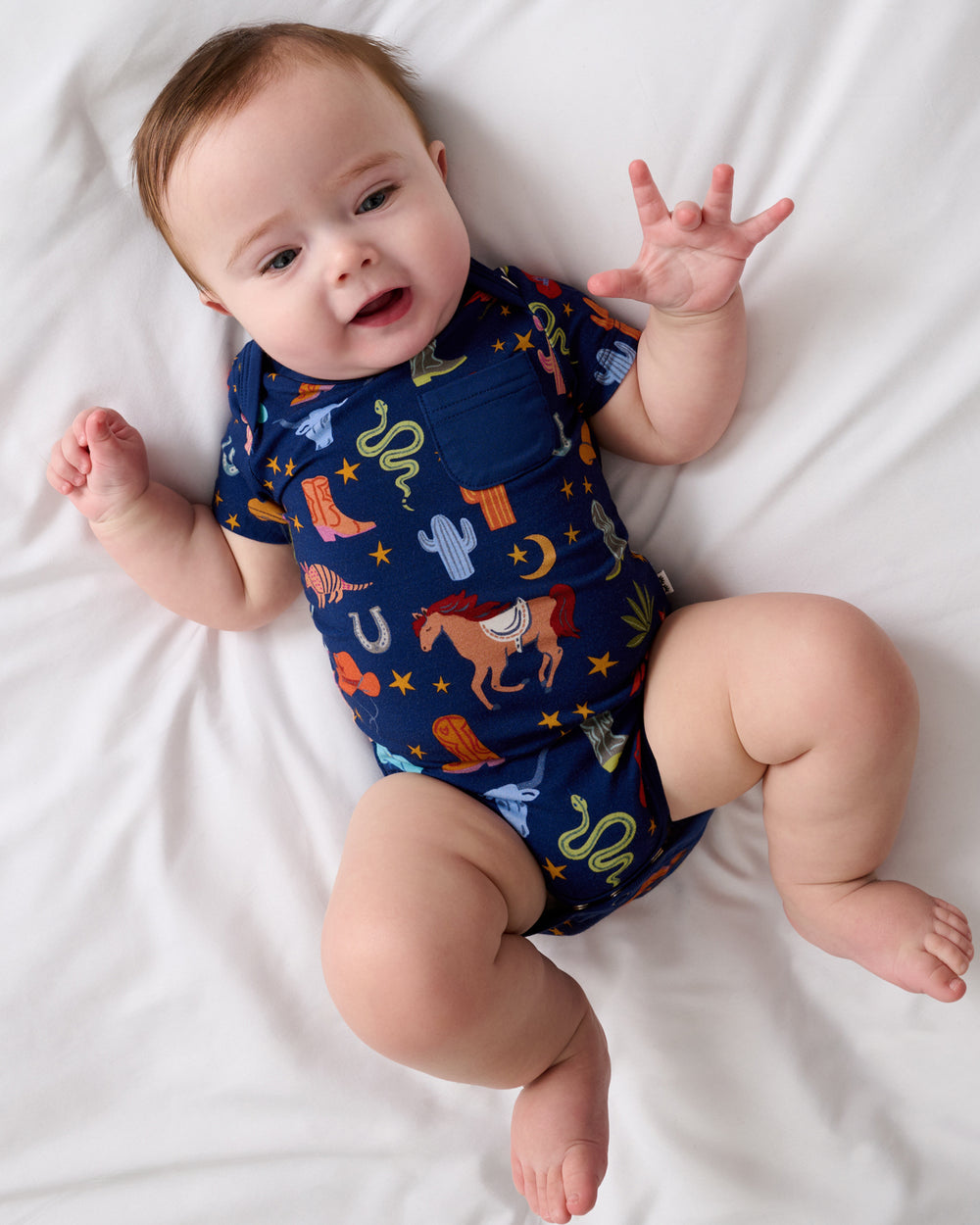 Aerial view of baby wearing the Blue Rancher Roundup Pocket Bodysuit