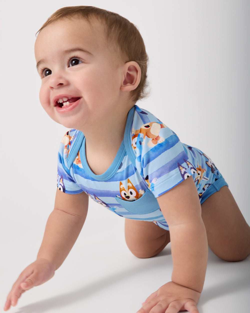 Crawling baby wearing the Bluey Dance All Day Pocket Bodysuit