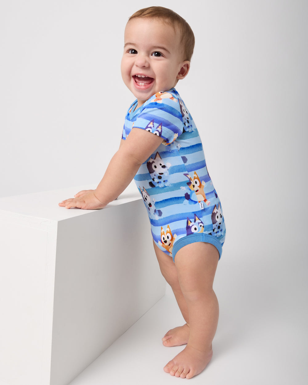Standing baby wearing the Bluey Dance All Day Pocket Bodysuit