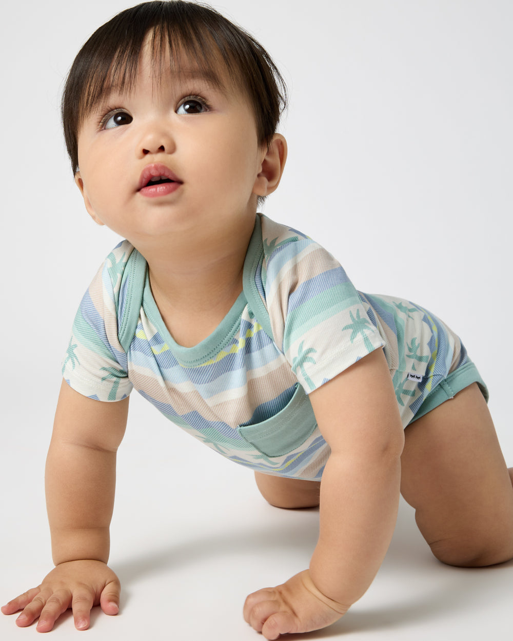 Crawling baby wearing the Swell Stripes Pocket Bodysuit