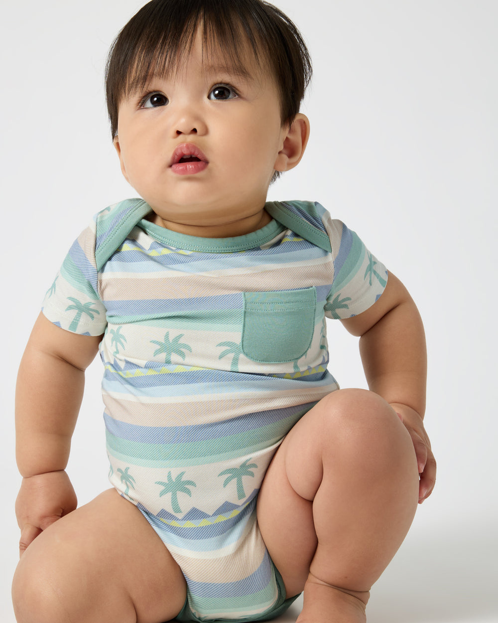 Sitting baby wearing the Swell Stripes Pocket Bodysuit