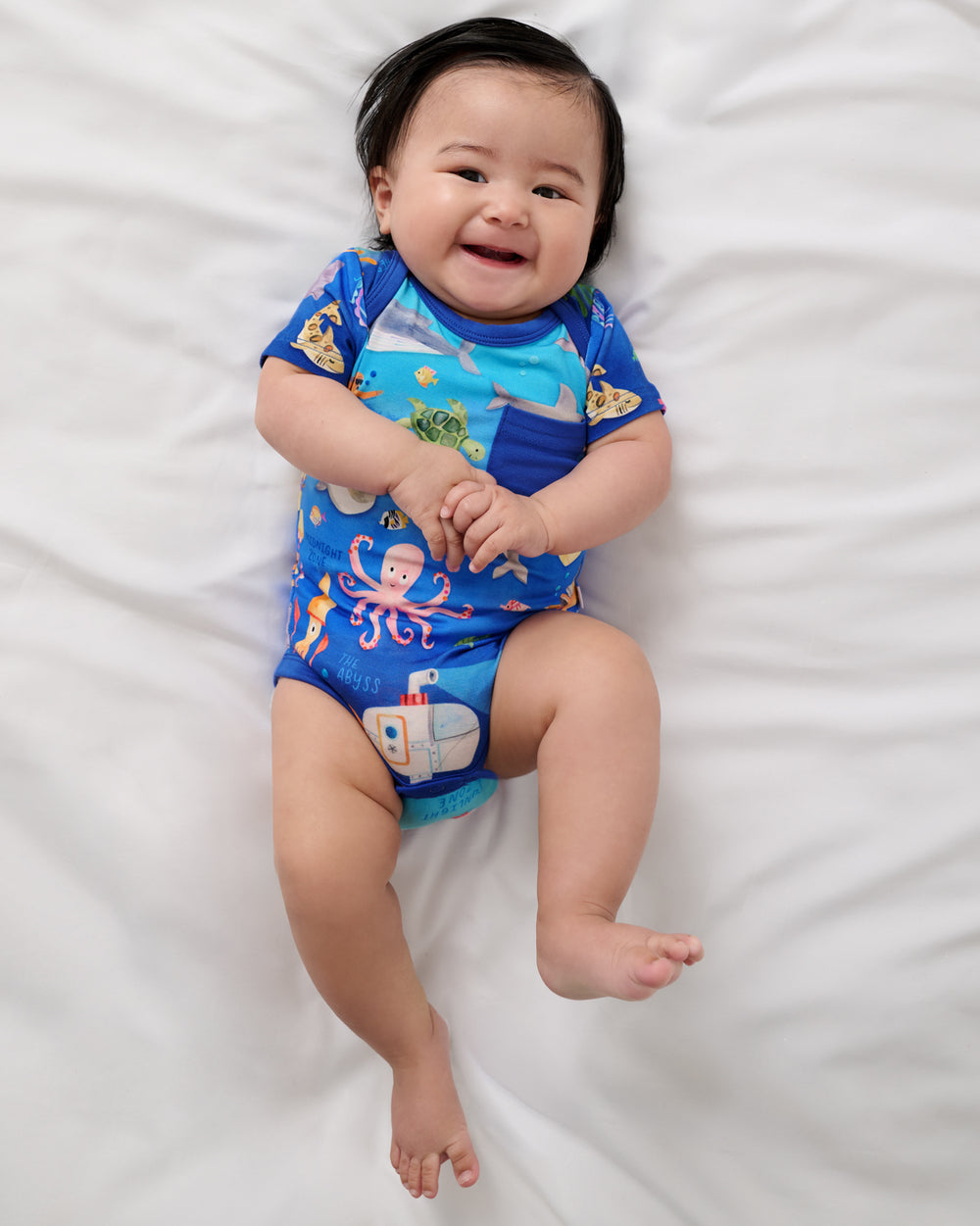Alternate aerial view of baby wearing the Underwater Discovery Pocket Bodysuit