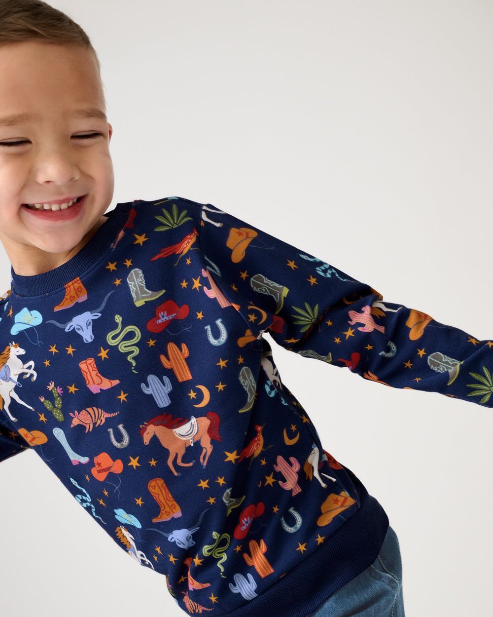 Smiling child wearing the Blue Rancher Roundup Crewneck Sweatshirt