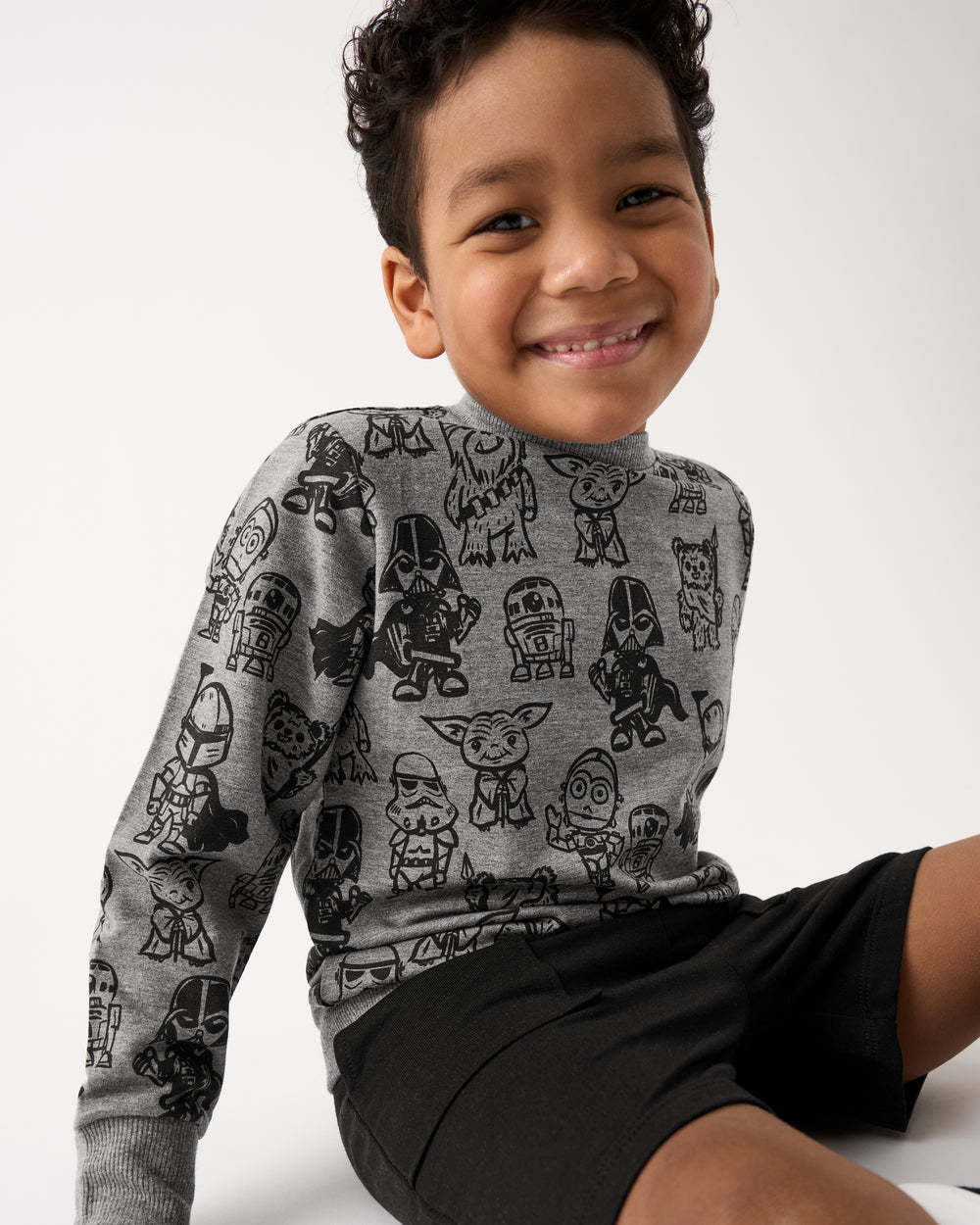 Sitting boy wearing the Star Wars Far, Far, Away Friends Crewneck Sweatshirt