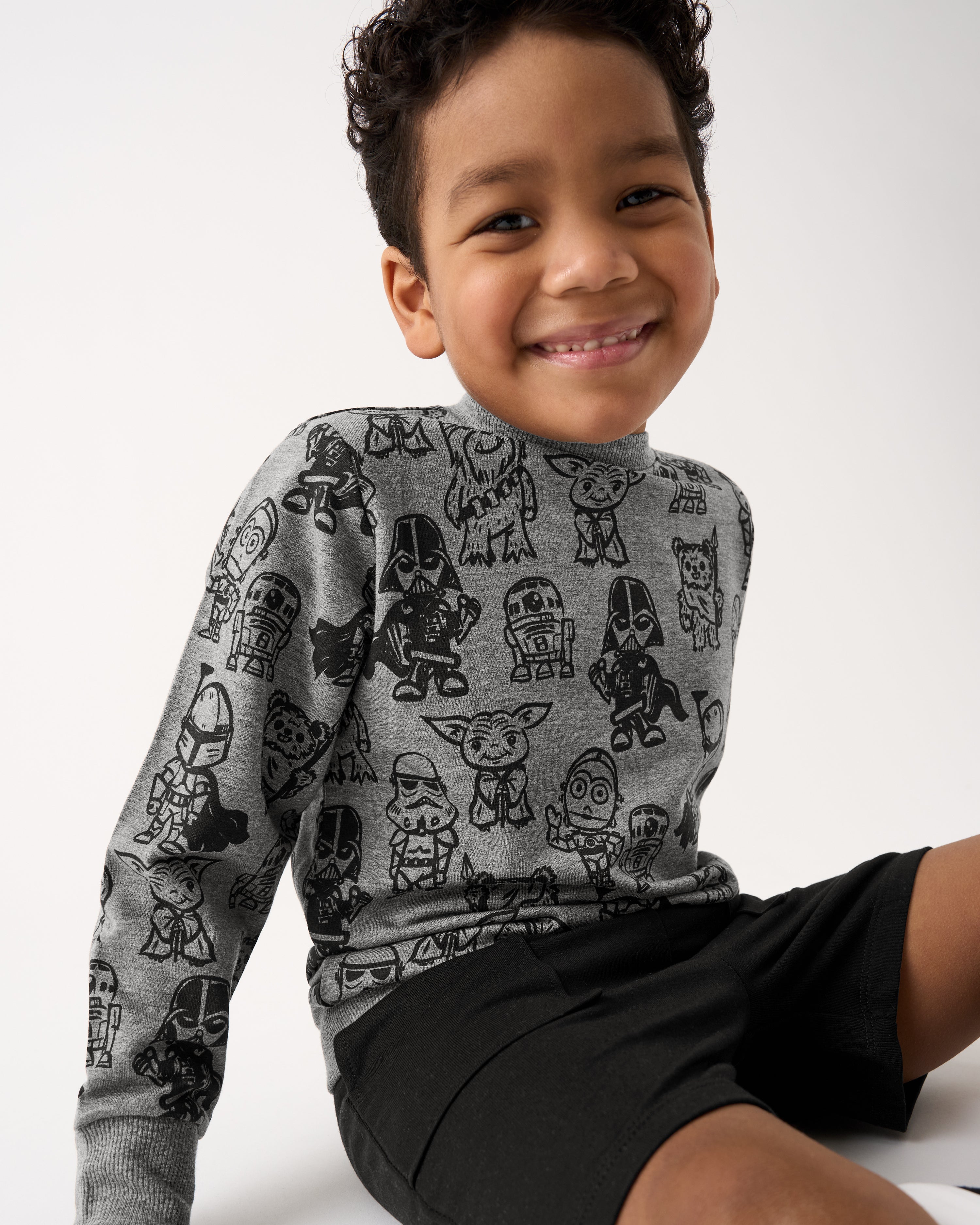 Sitting boy wearing the Star Wars Far, Far, Away Friends Crewneck Sweatshirt
