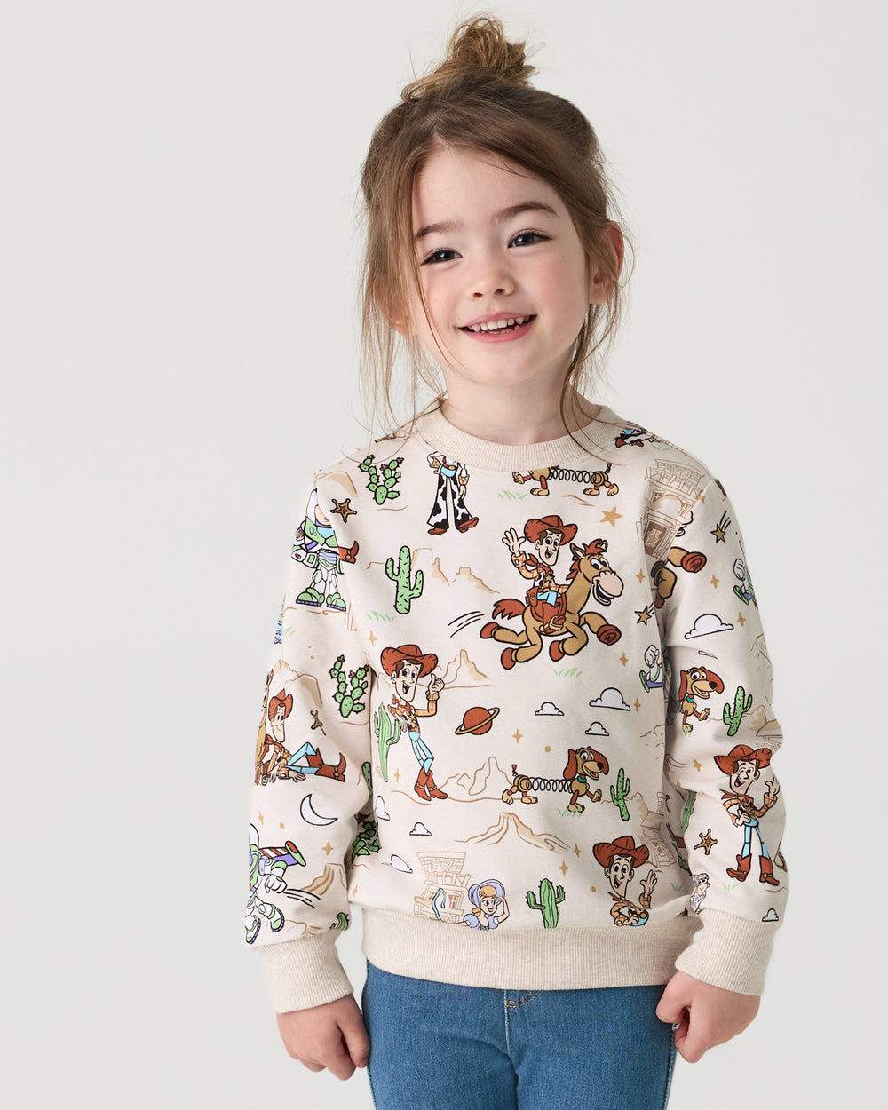 Girl wearing the Disney & Pixar Woody's Wild West Crewneck Sweatshirt