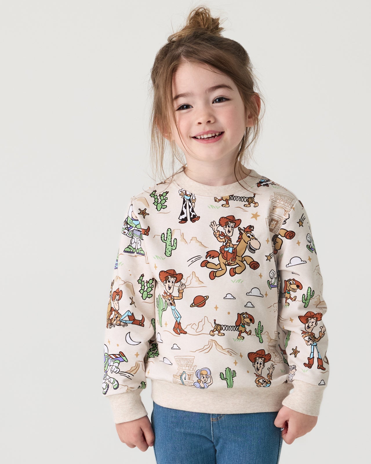 Girl wearing the Disney & Pixar Woody's Wild West Crewneck Sweatshirt