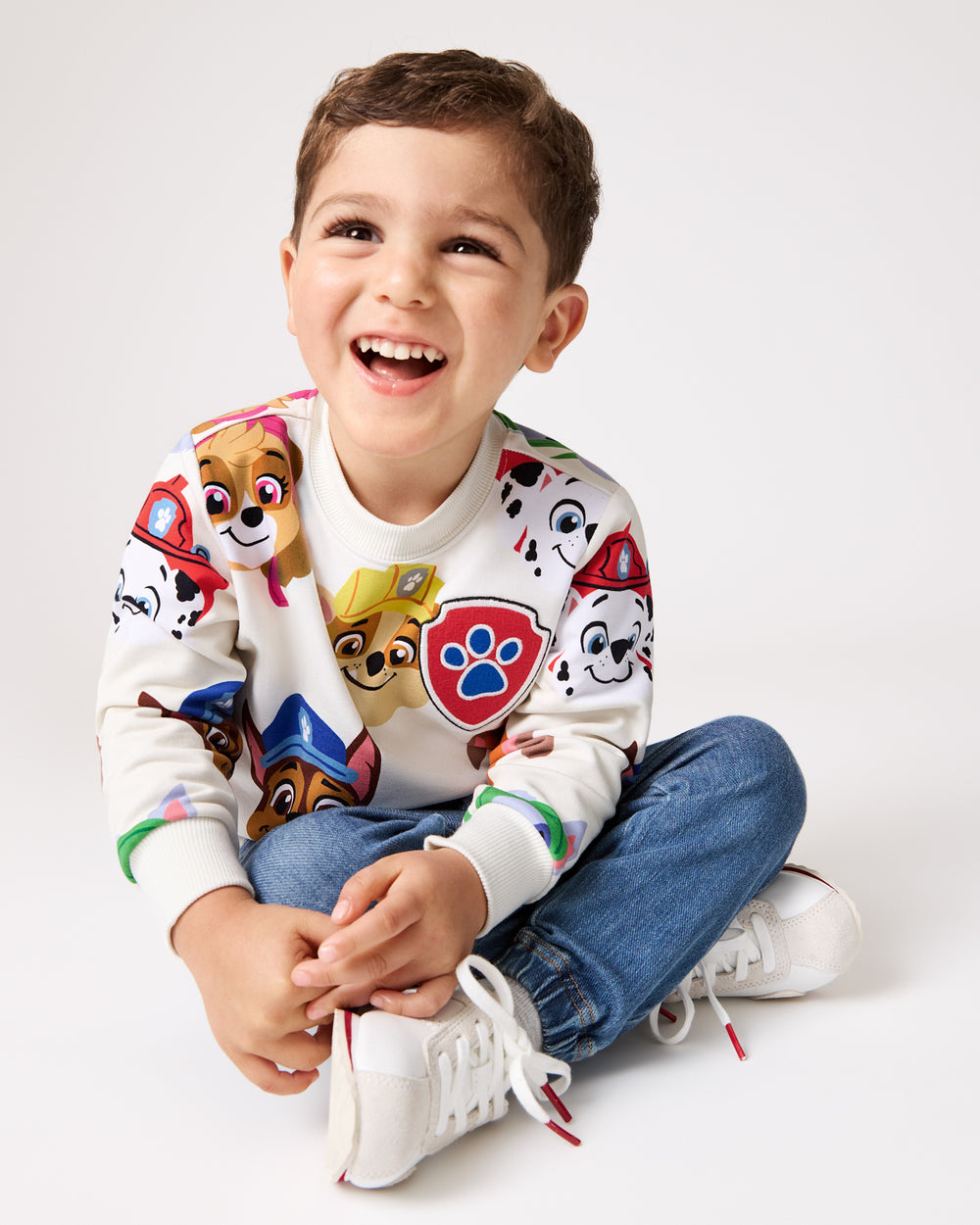 Sitting boy wearing the PAW Patrol Rescue Ready Crewneck Sweatshirt
