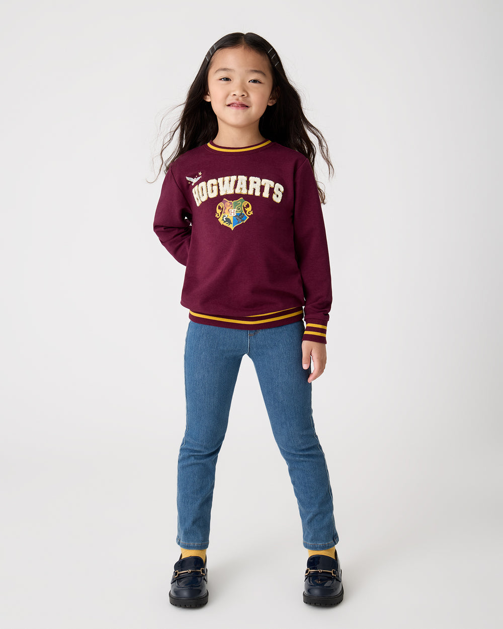 Girl wearing the Harry Potter™ Spellbinding Studies Crewneck Sweatshirt with denim pants
