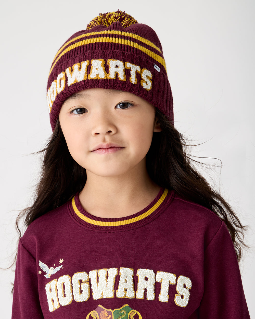 Girl wearing the Harry Potter™ Spellbinding Studies Sweater Beanie