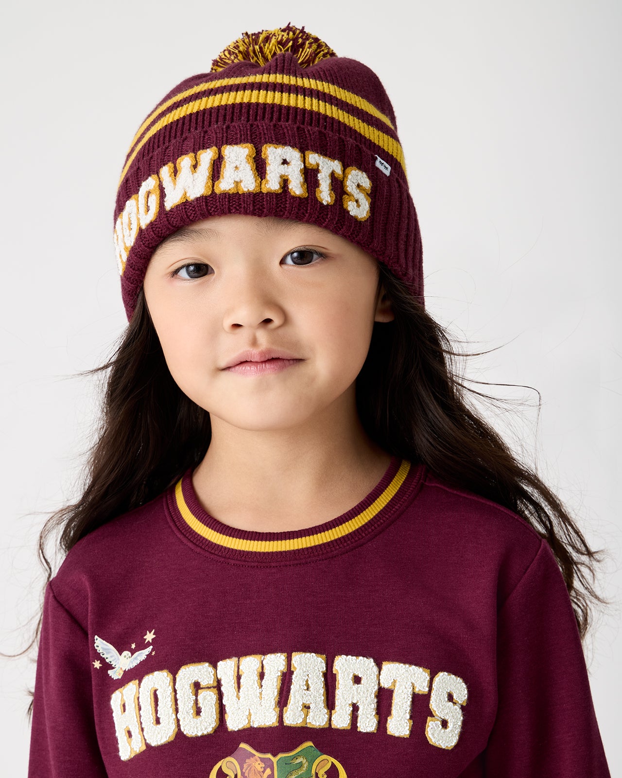Girl wearing the Harry Potter™ Spellbinding Studies Sweater Beanie