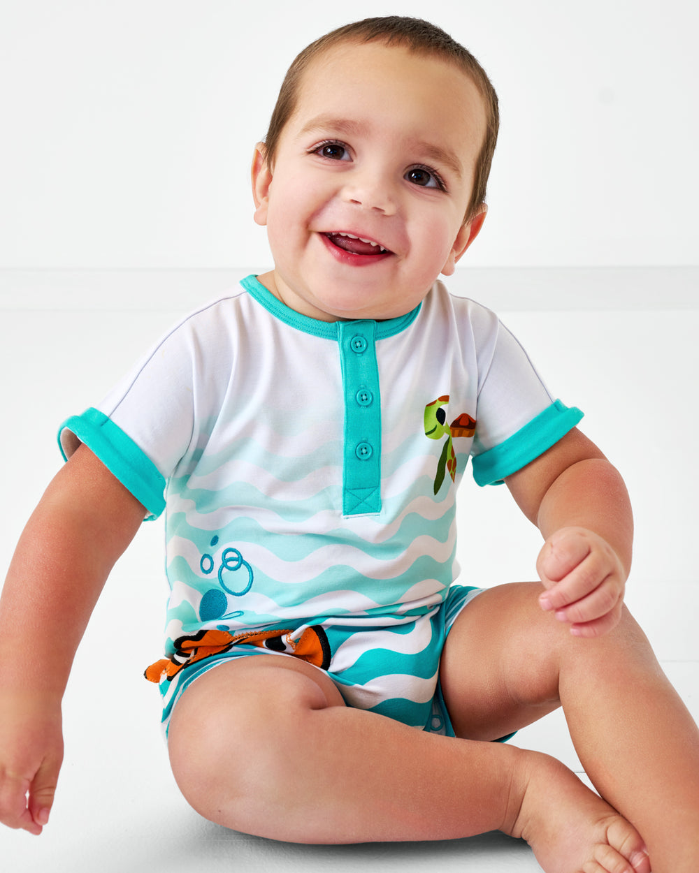 Sitting baby wearing the Pixar Nemo Dolman Henley Romper