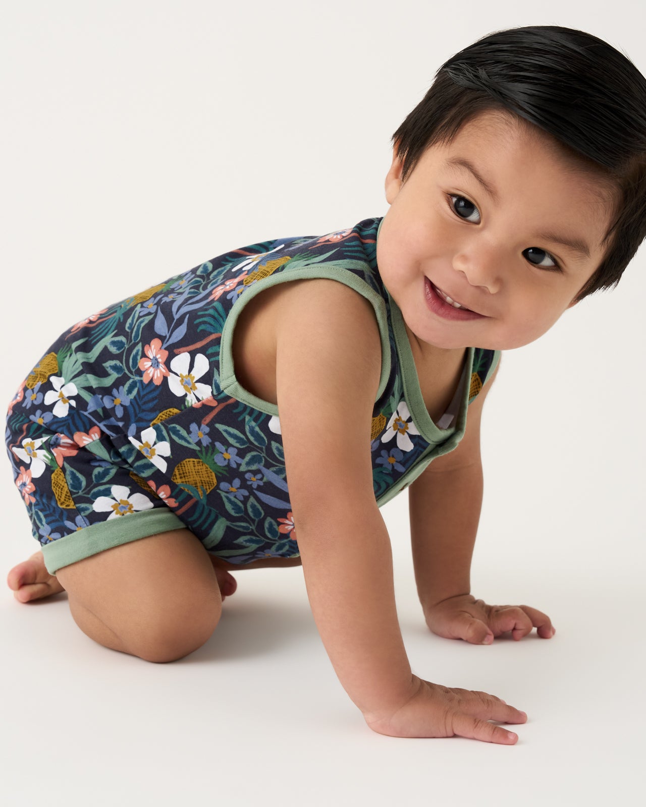 Crawling baby wearing the Tropical Garden Henley Romper