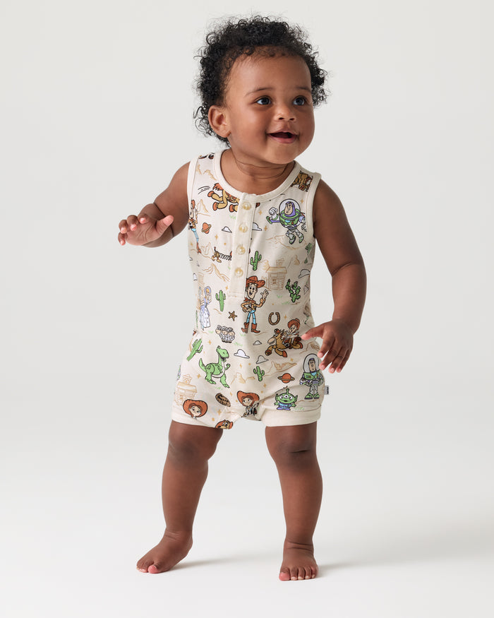 Walking toddler wearing the Disney & Pixar Woody's Wild West Henley Romper