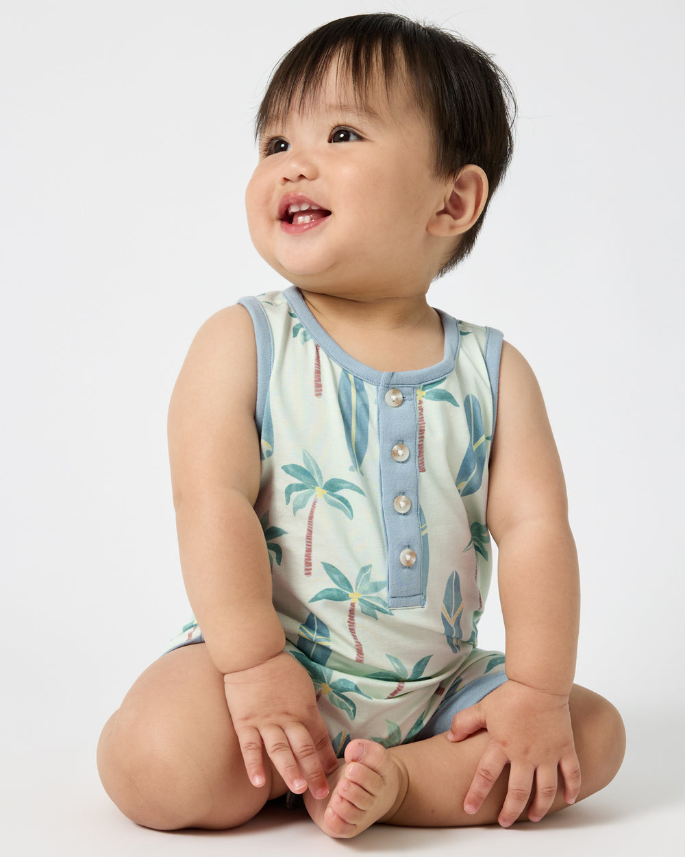 Sitting baby wearing the Palm Dunes Tank Button Romper