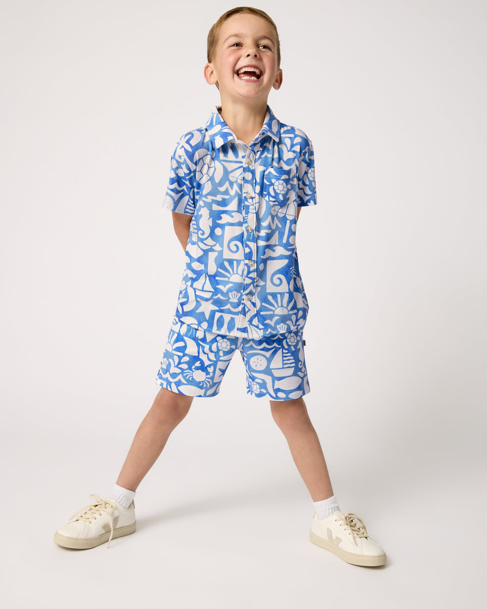 Boy wearing the Summer Shores Button Down Polo and Shorts with white sneakers