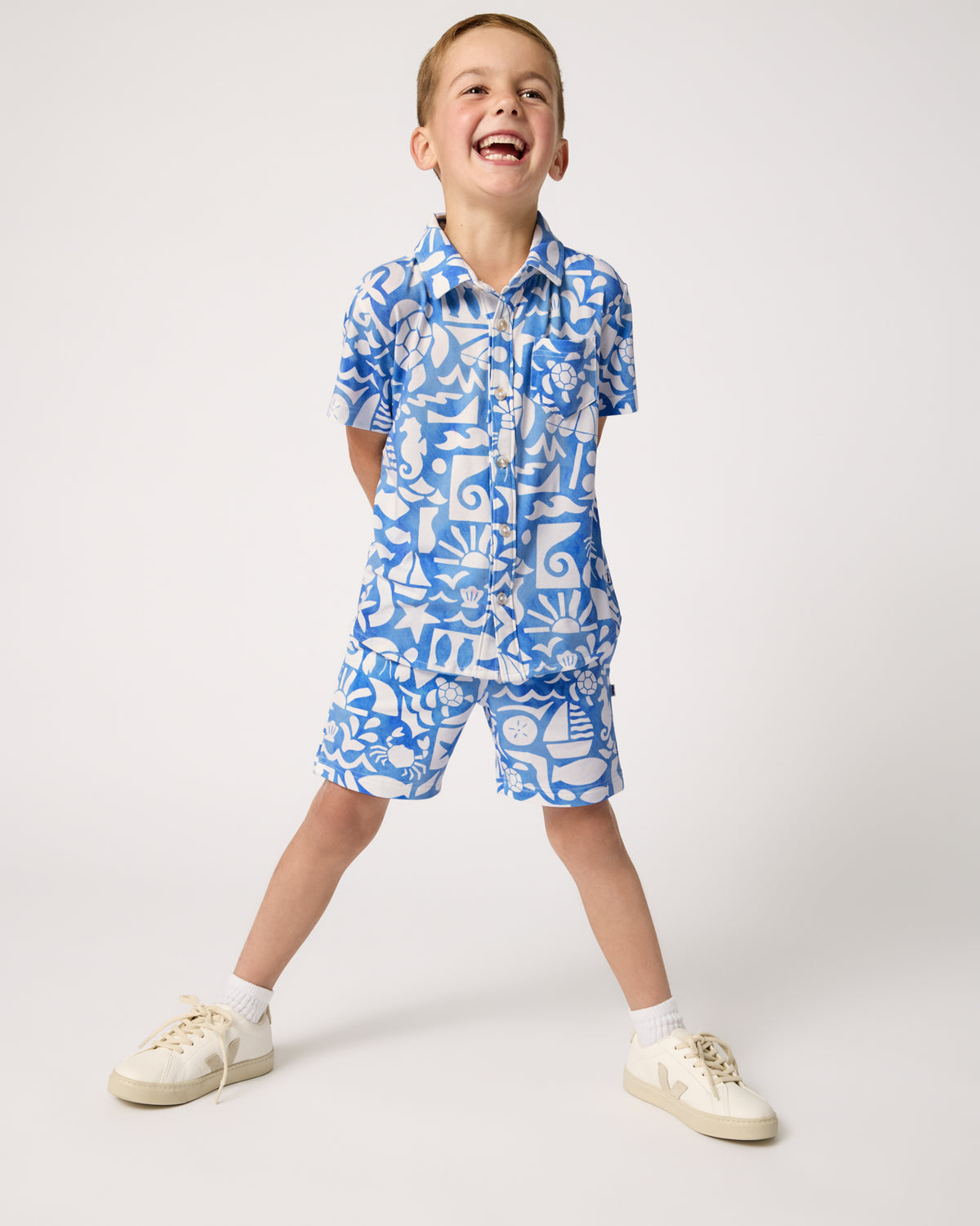Boy wearing the Summer Shores Button Down Polo and Shorts with white sneakers
