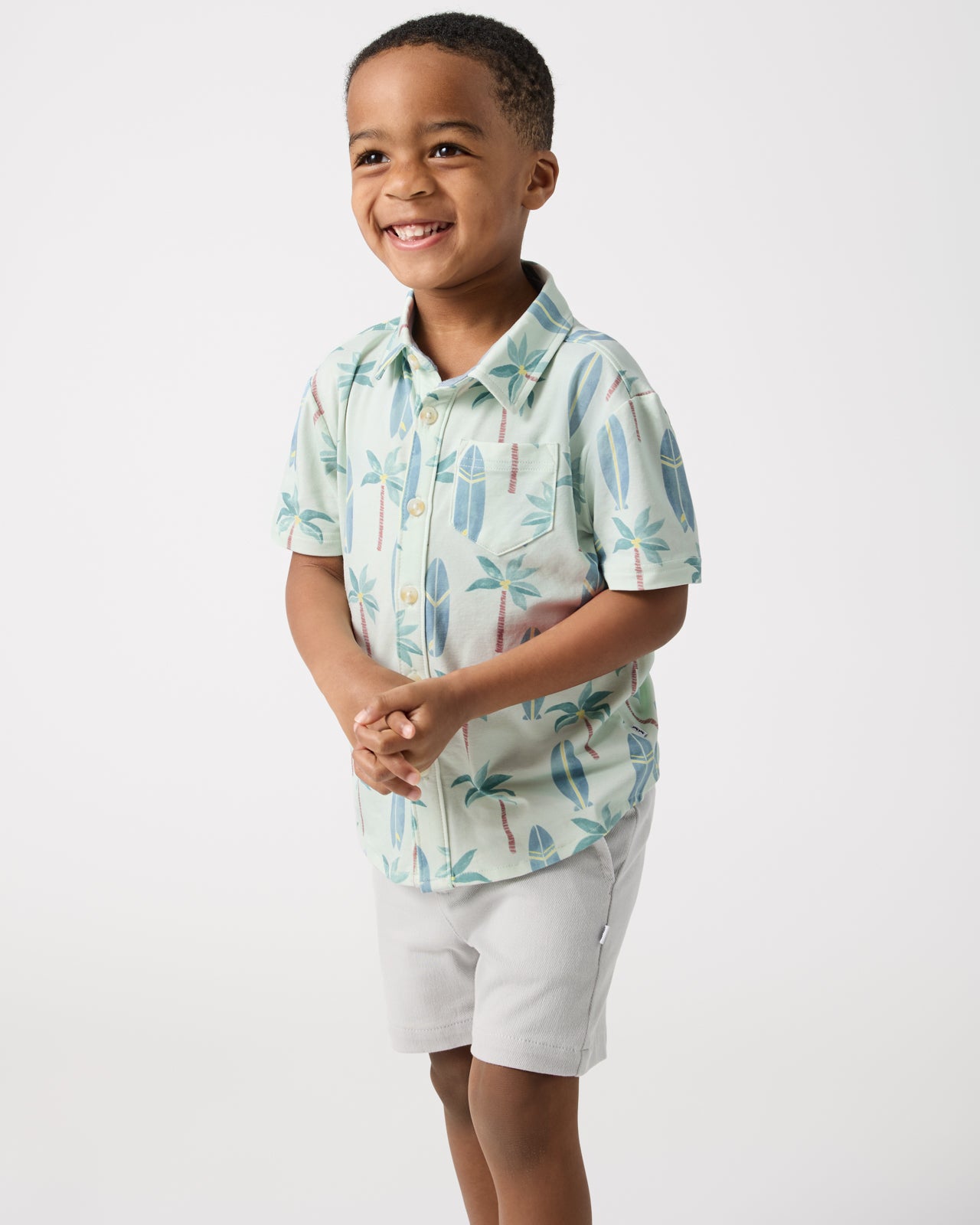 Boy wearing the Palm Dunes Button Down Polo with gray shorts