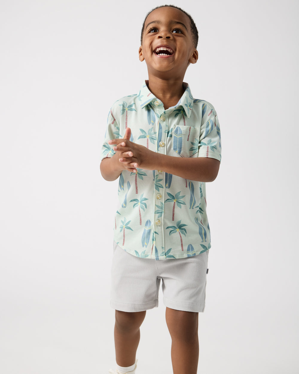 Smiling child wearing the Palm Dunes Button Down Polo