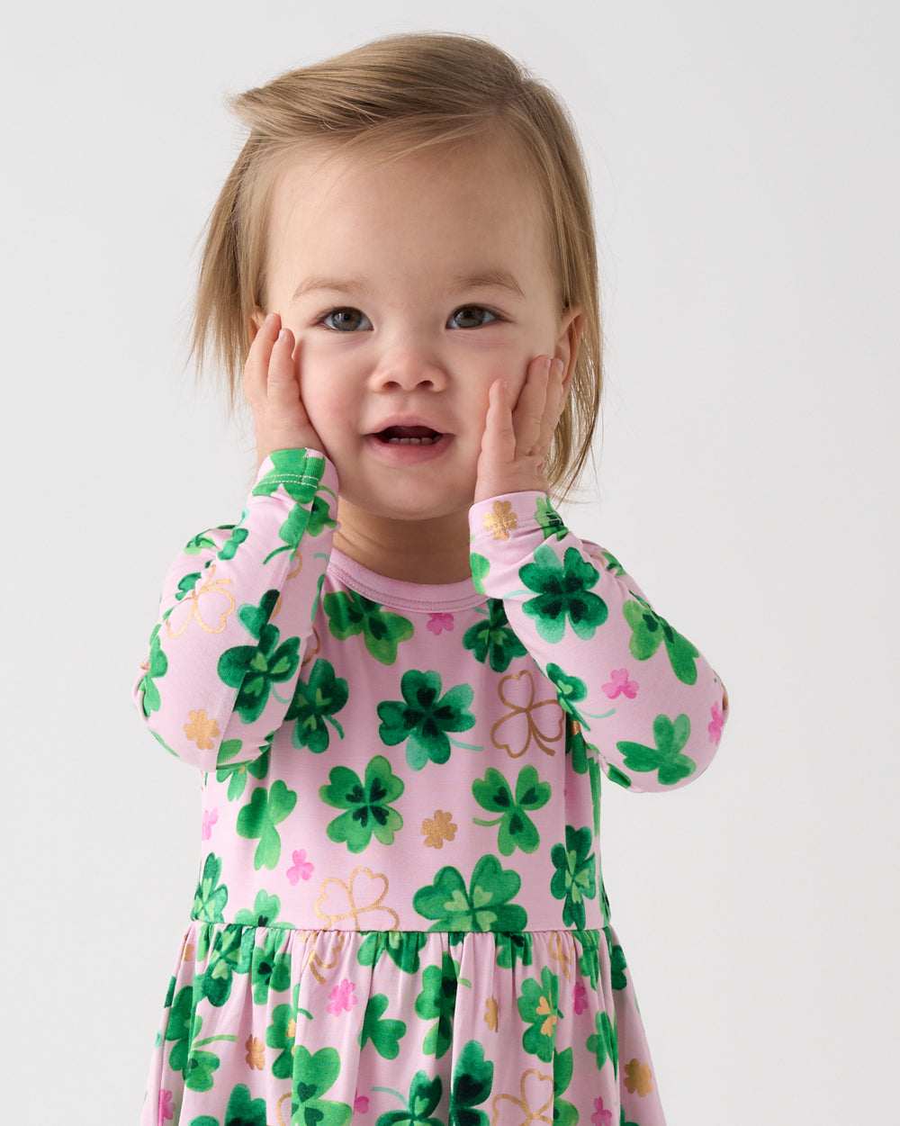 Posing girl wearing the Clover Cuties Twirl Dress with Bodysuit