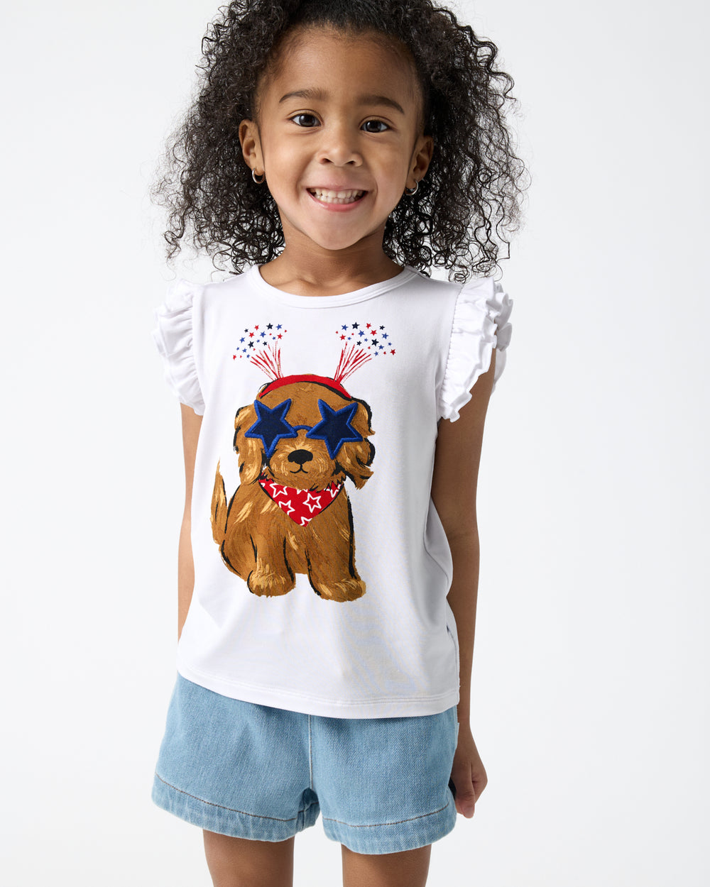 Close up of girl wearing the Star Spangled Pup Flutter Tee and denim shorts