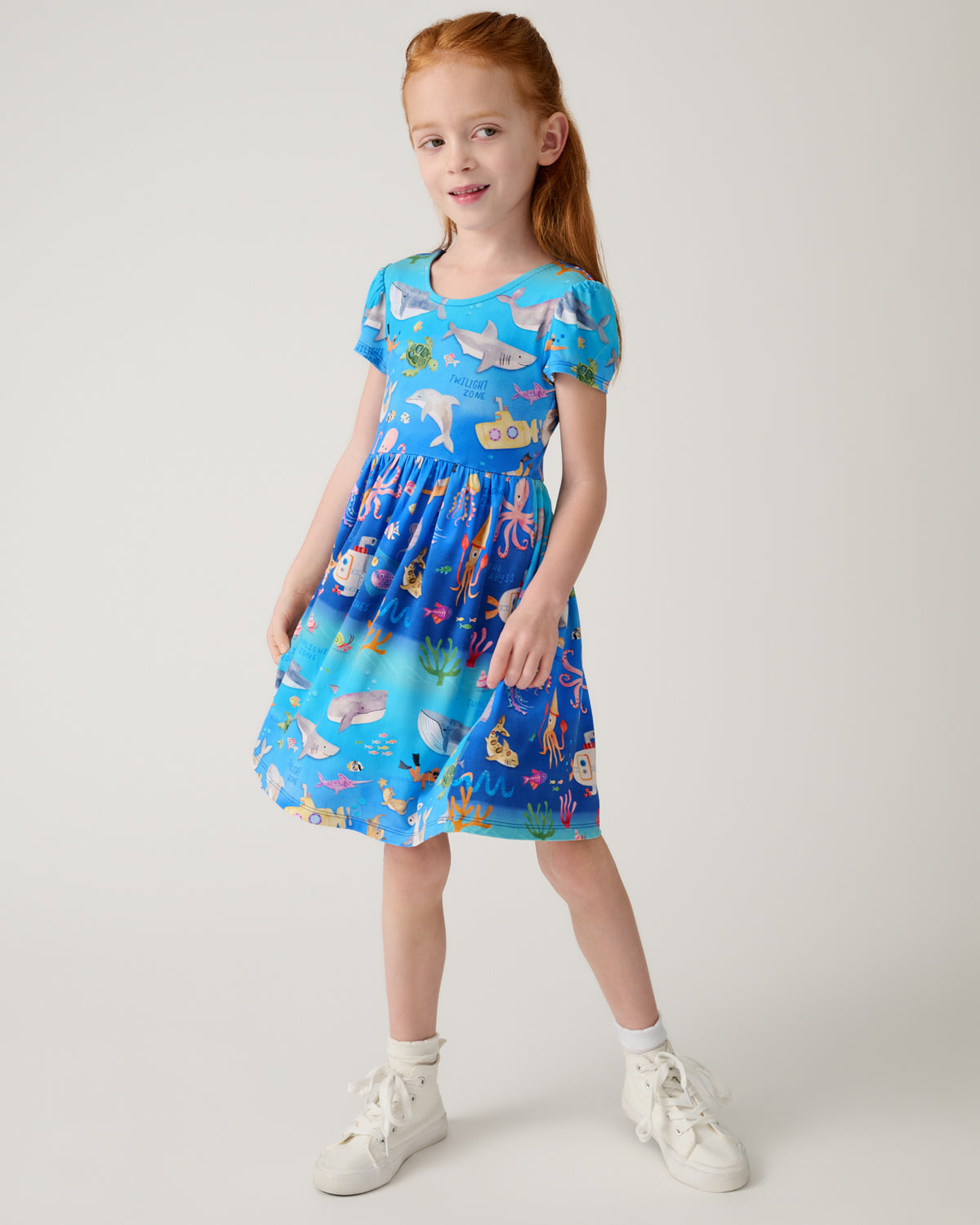 Standing girl wearing the Underwater Discovery Bow Back Skater Dress