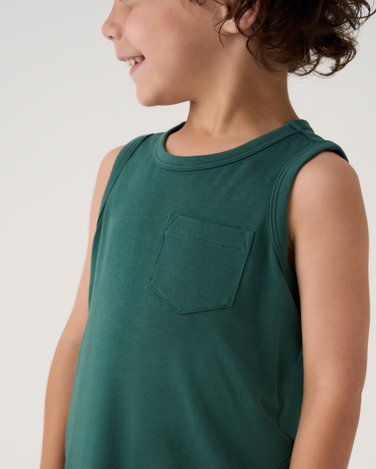 Close up of boy wearing the Muted Spruce Pocket Tank