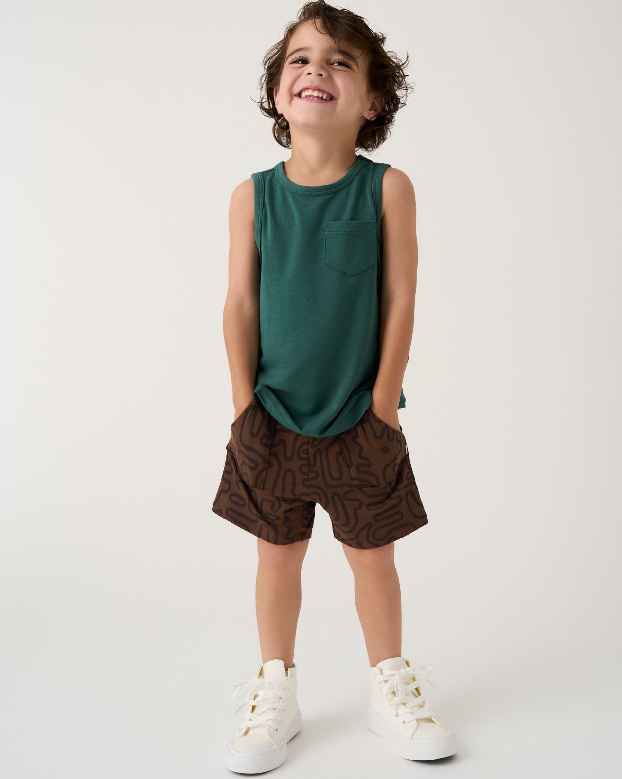 Boy wearing the Muted Spruce Pocket Tank and Dino Maze Shorts