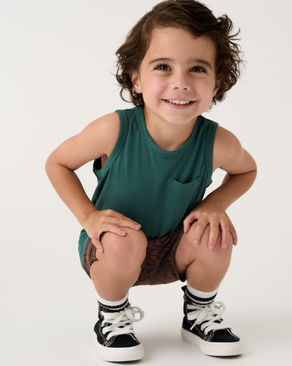 Boy wearing the Muted Spruce Pocket Tank with black sneakers