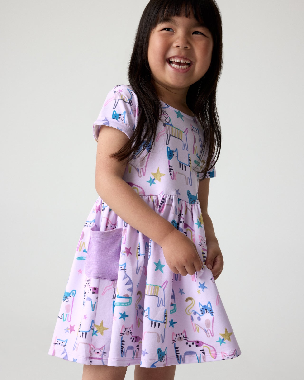 Close up of girl wearing the Whiskers & Wags Purple Patch Pocket Dress