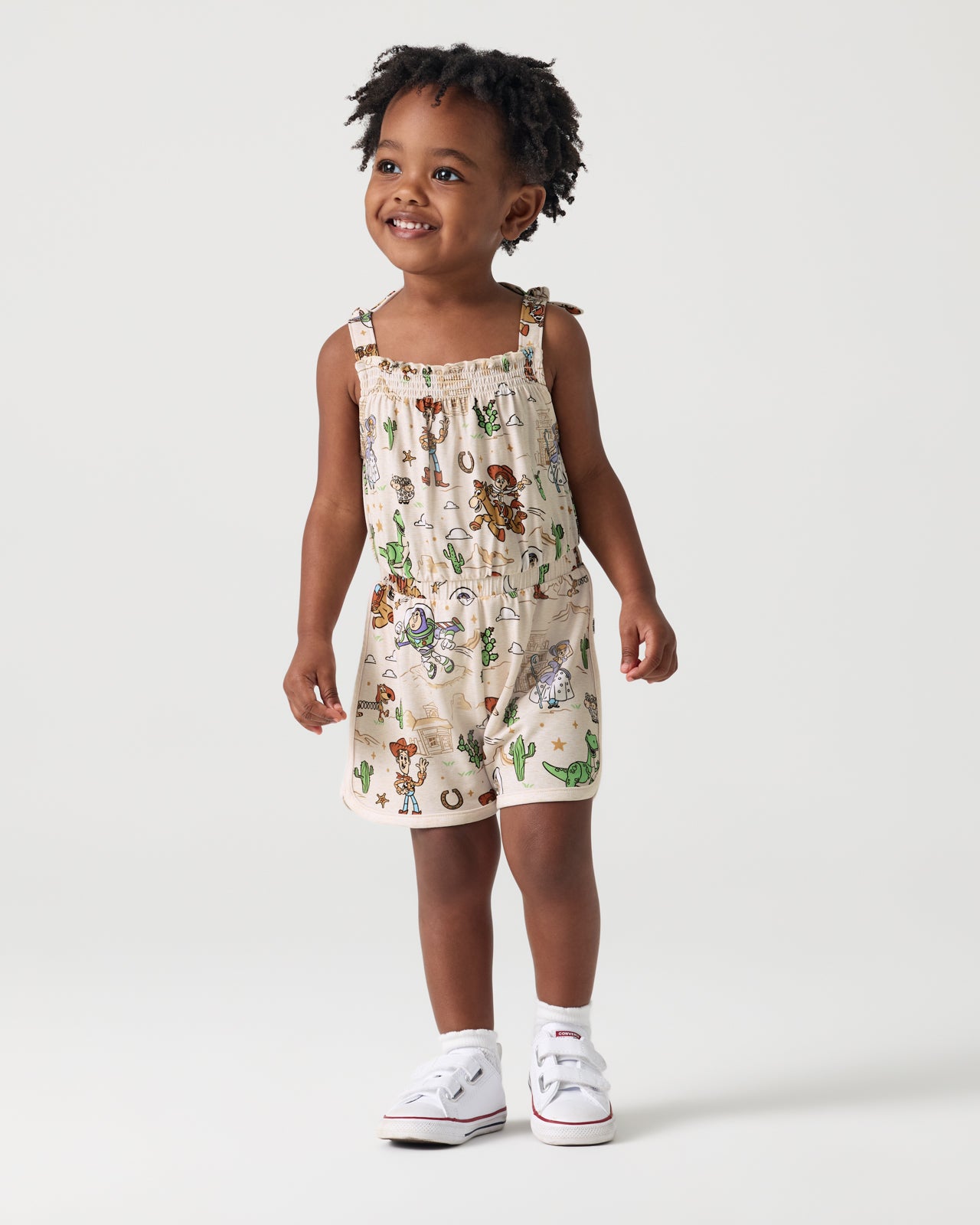Girl wearing the Disney & Pixar Woody's Wild West Smocked Romper