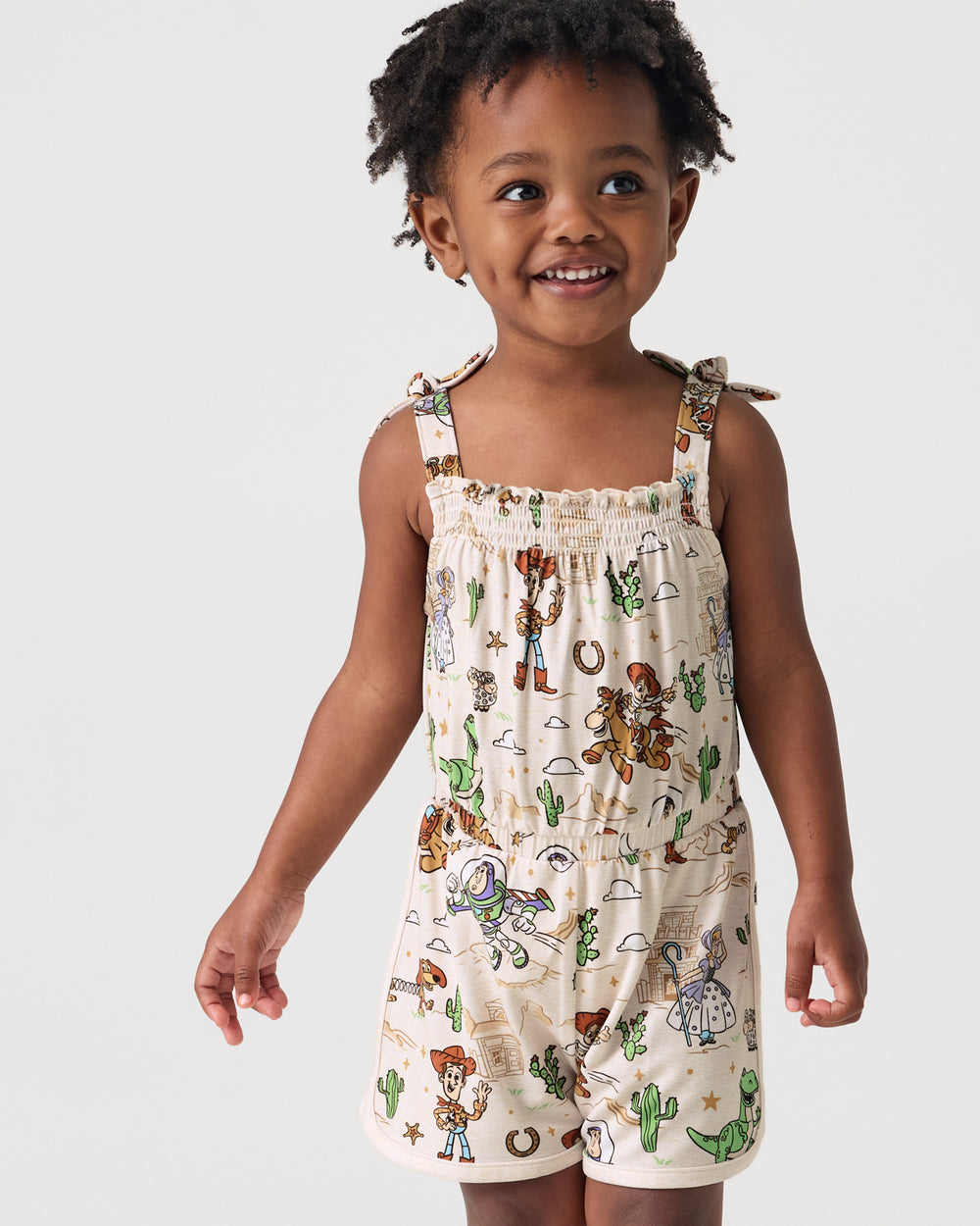 Close up of girl wearing he Disney & Pixar Woody's Wild West Smocked Romper