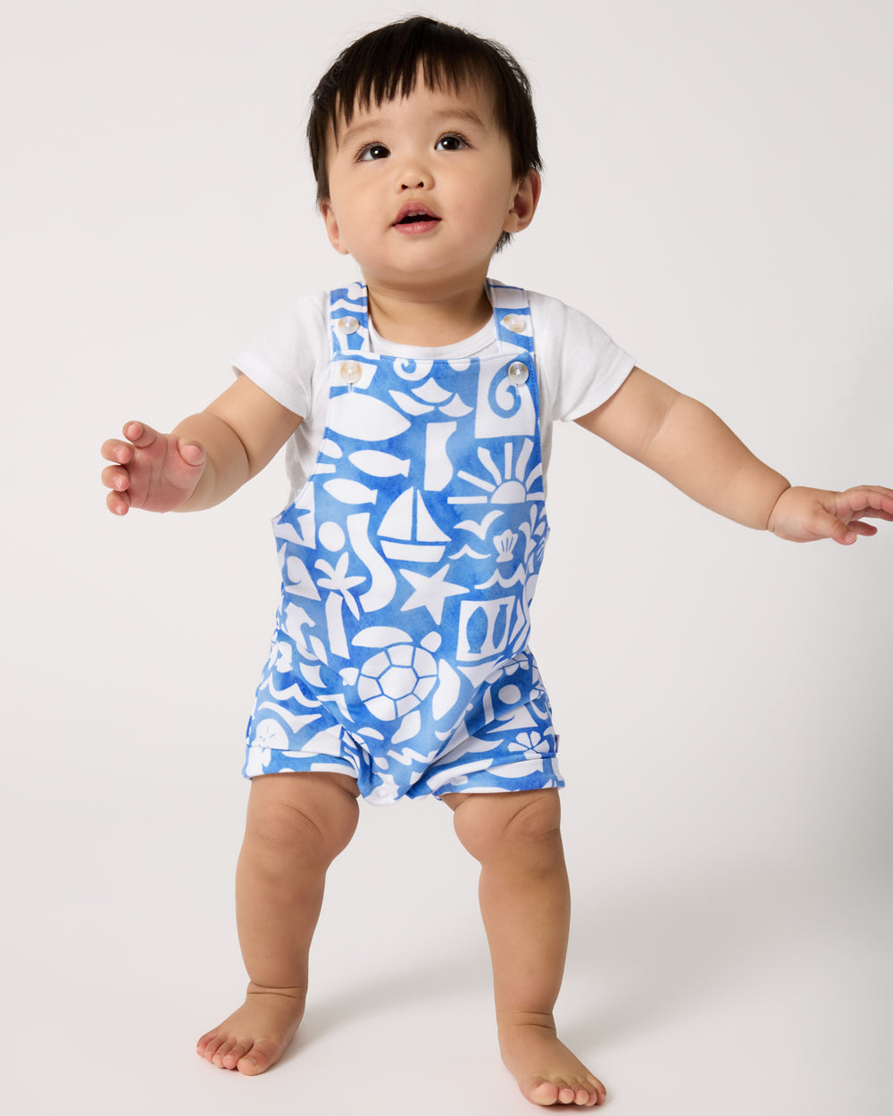 Standing baby wearing the Summer Shores Shorty Overall