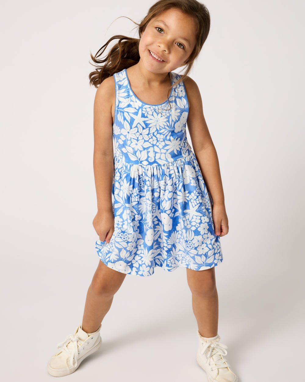Girl wearing the Azure Garden Cross Back Skater Dress with white sneakers