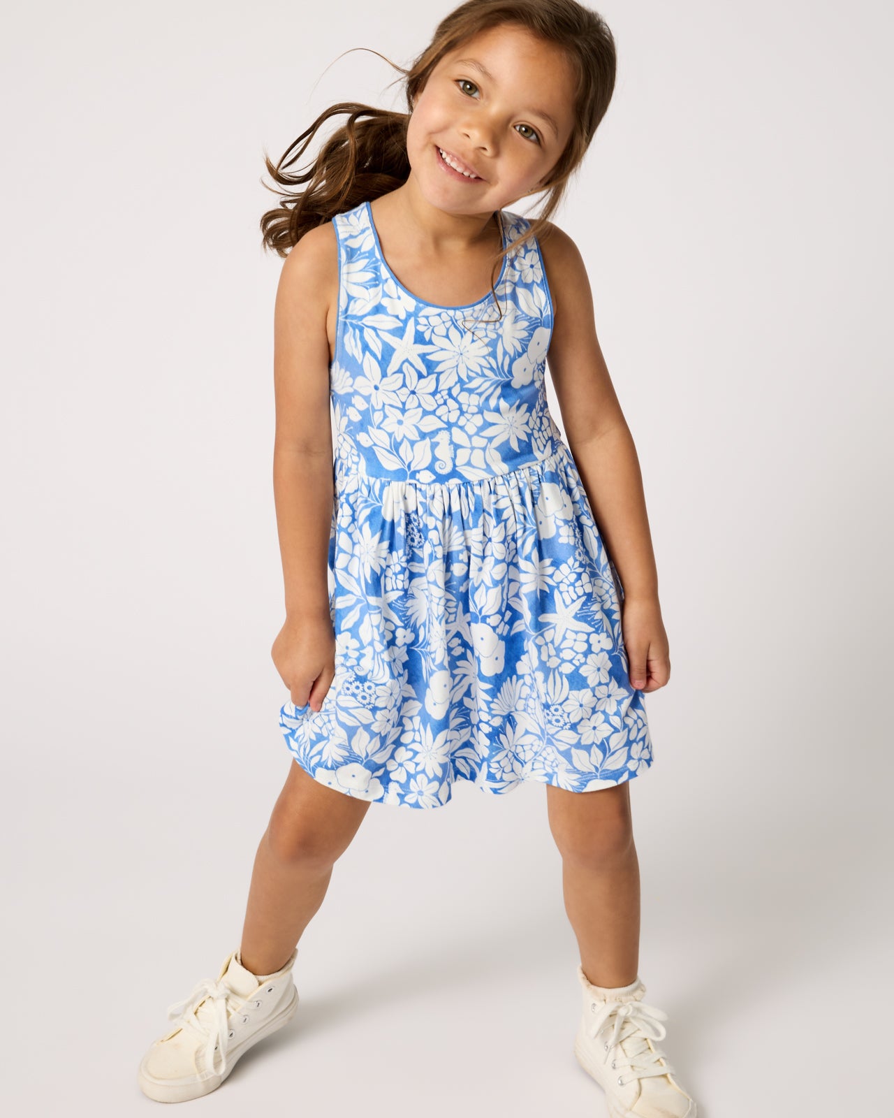 Girl wearing the Azure Garden Cross Back Skater Dress with white sneakers