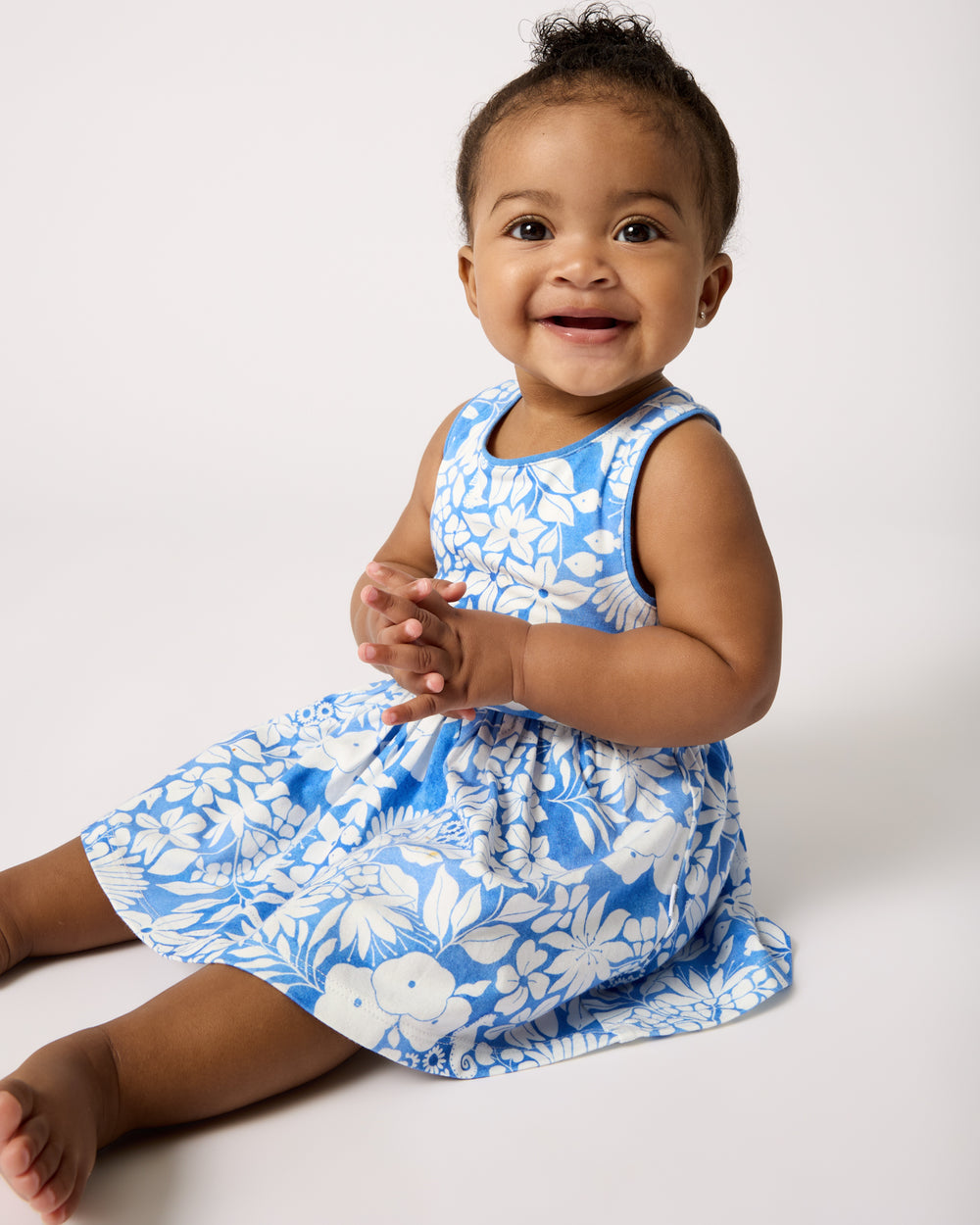 Sitting girl wearing the Azure Garden Cross Back Skater Dress with Bloomer