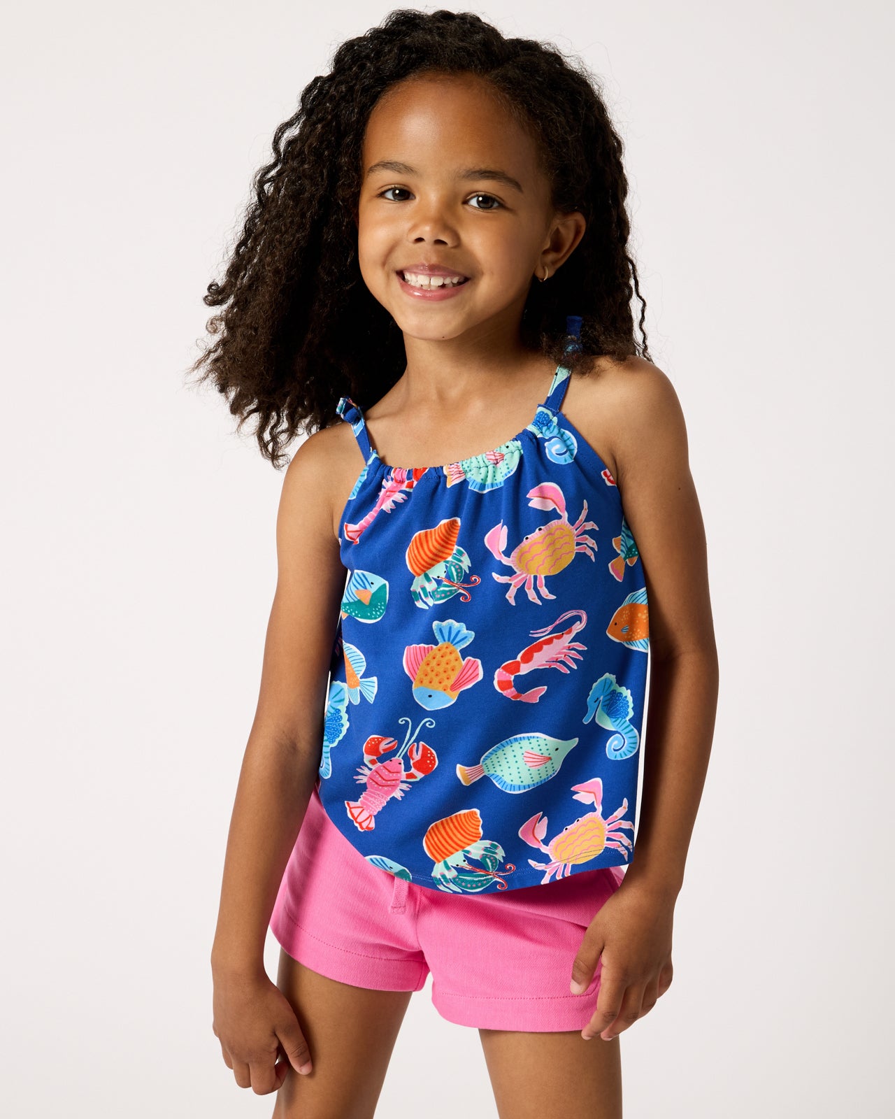 Girl wearing the Tidepool Party Bow Strap Tank with Pink Denim Shorts