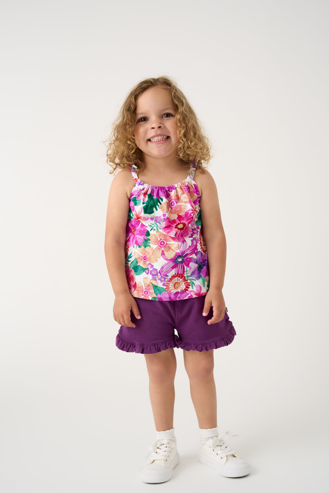 Girl wearing the Royal Violet Ruffle Shorts with a floral tank