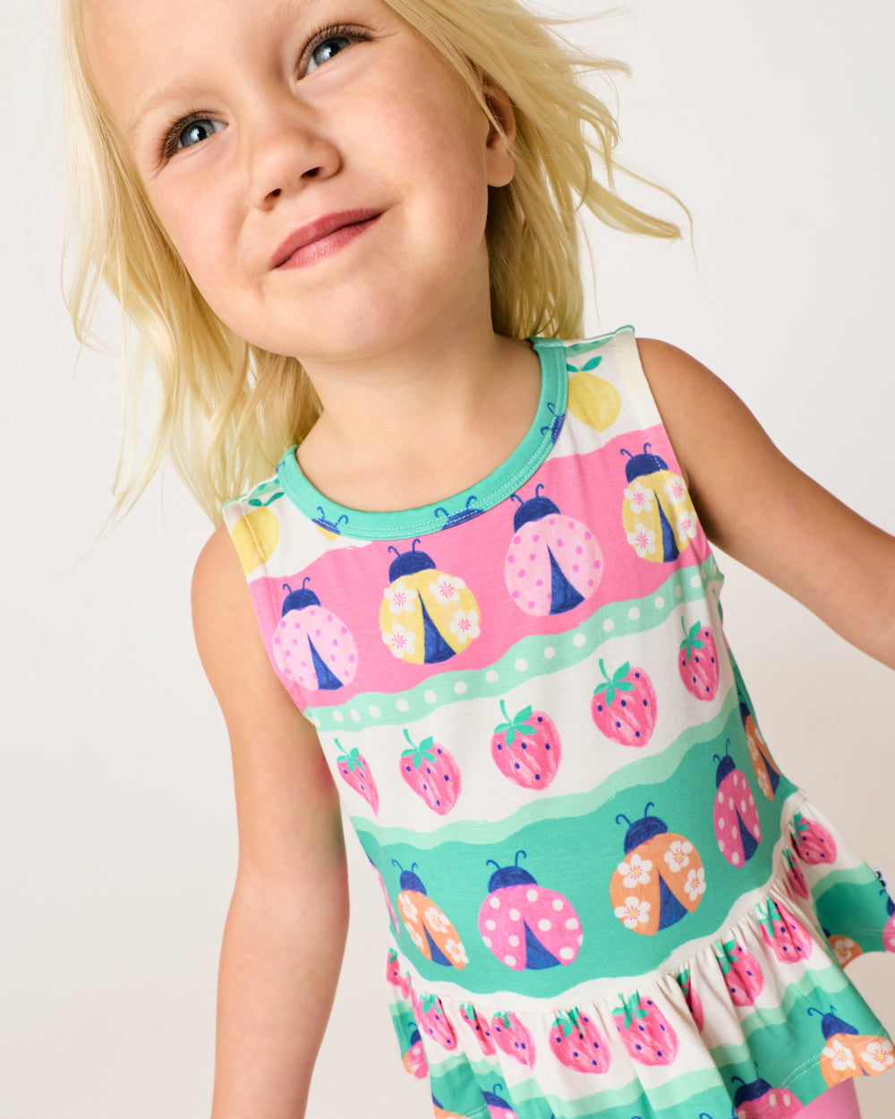 Close up of child wearing the Ladybug Lane Peplum Tank