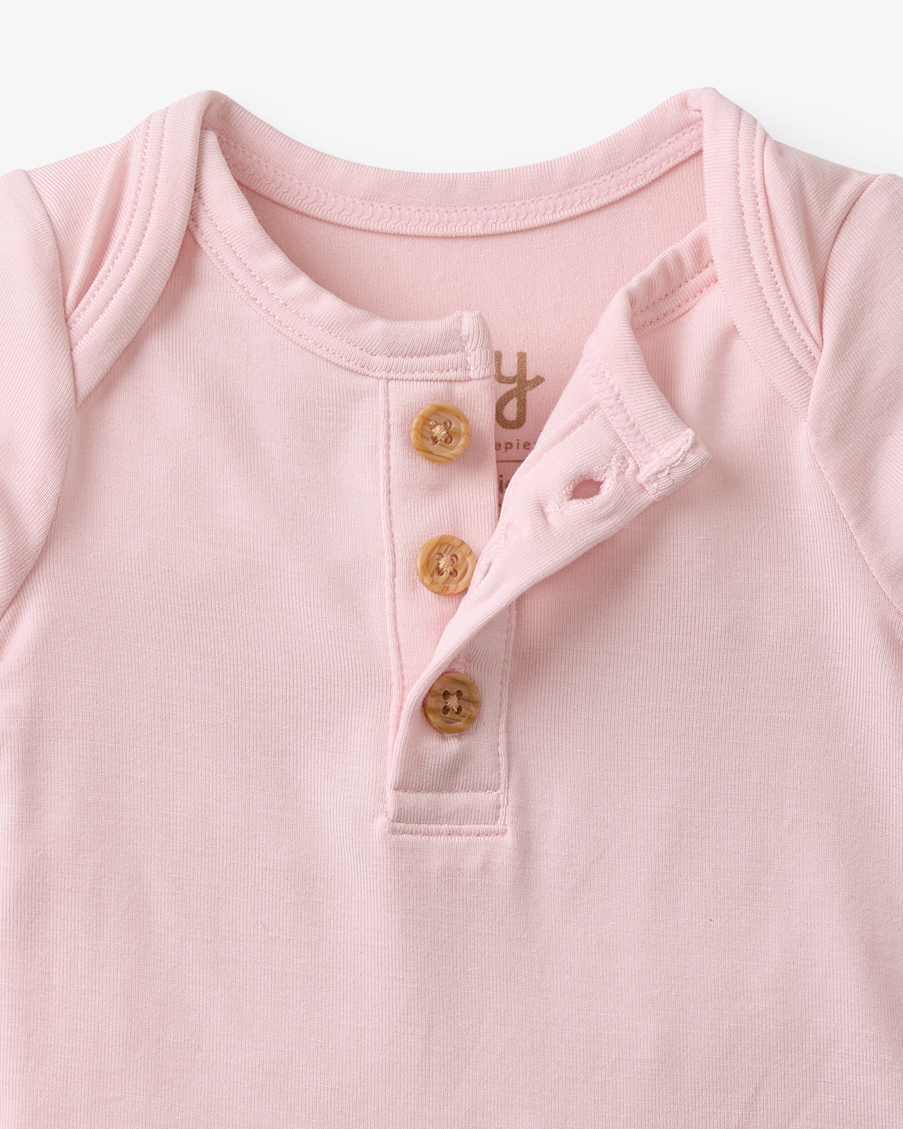 Close up flat lay of the button detail on the Prima Pink Henley Bodysuit